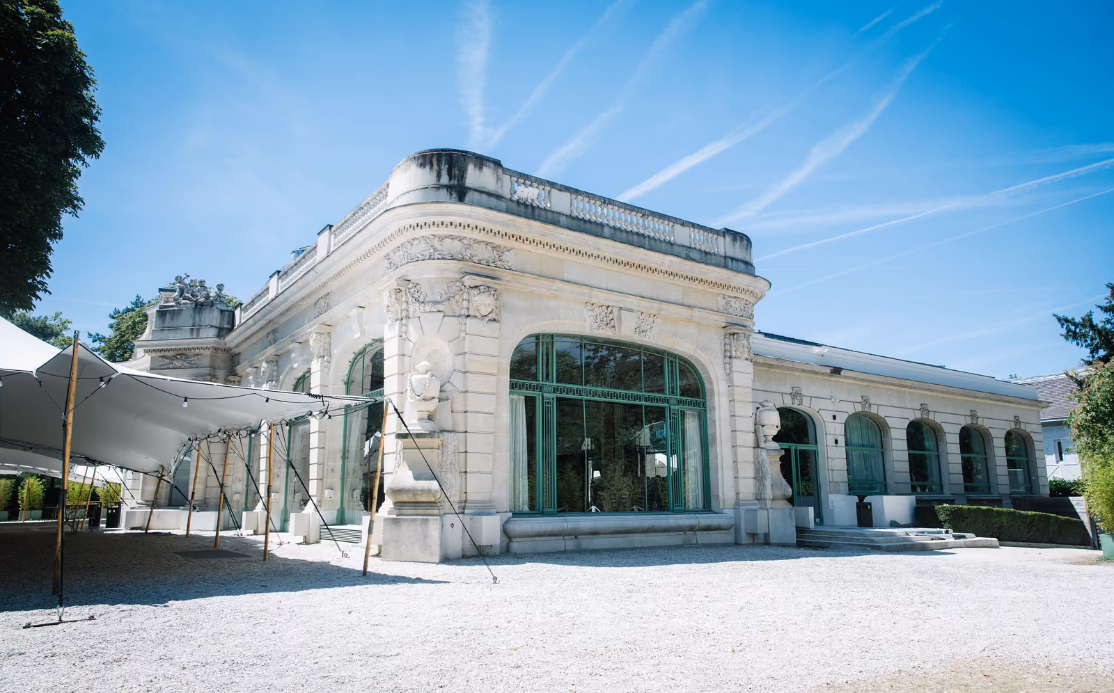 Façade vitrée de l'orangerie du domaine, sous un ciel bleu