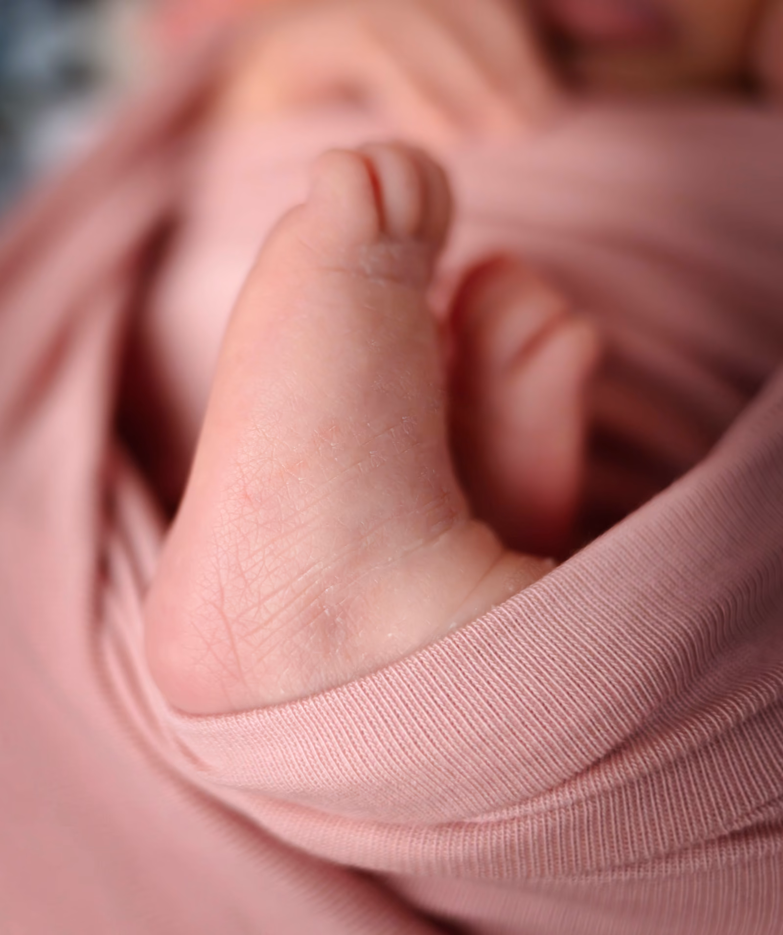 Gros plan sur un petit pied qui dépasse d'un lange rose