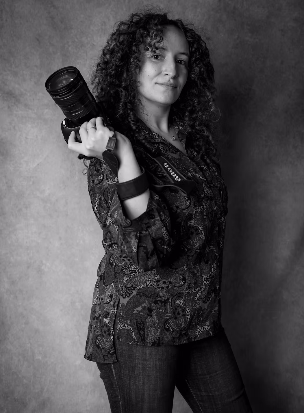 Sarah, photographe, tenant son appareil photo — portrait en noir et blanc